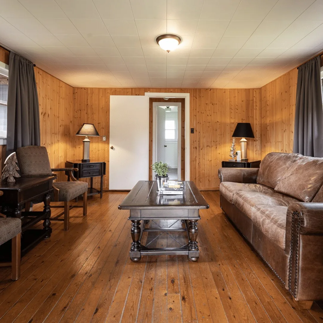 Woodside Cabin living room with wood walls and upholstered seating at Killarney Mountain Lodge