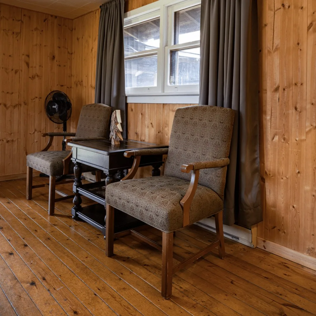 Woodside Cabin sitting area with armchairs and a desk at Killarney Mountain Lodge
