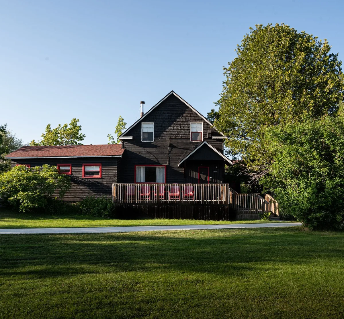Historic East House exterior and lawn in the green season at Killarney Mountain Lodge