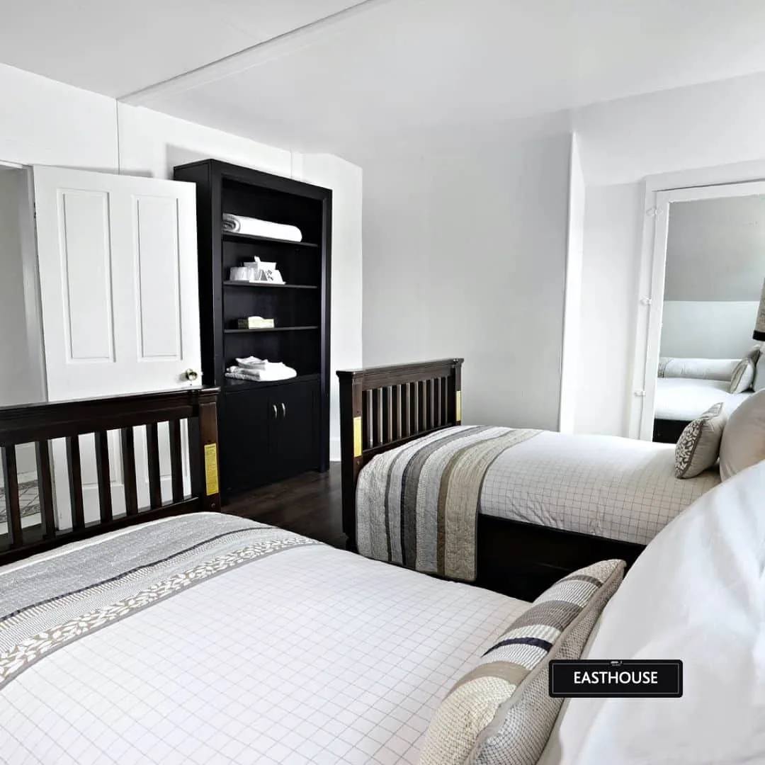 Historic East House twin bedroom with dark wood furniture at Killarney Mountain Lodge