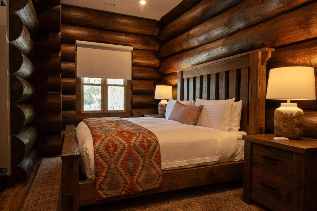 Log-cabin bedroom with timber walls and a wood headboard at Killarney Mountain Lodge