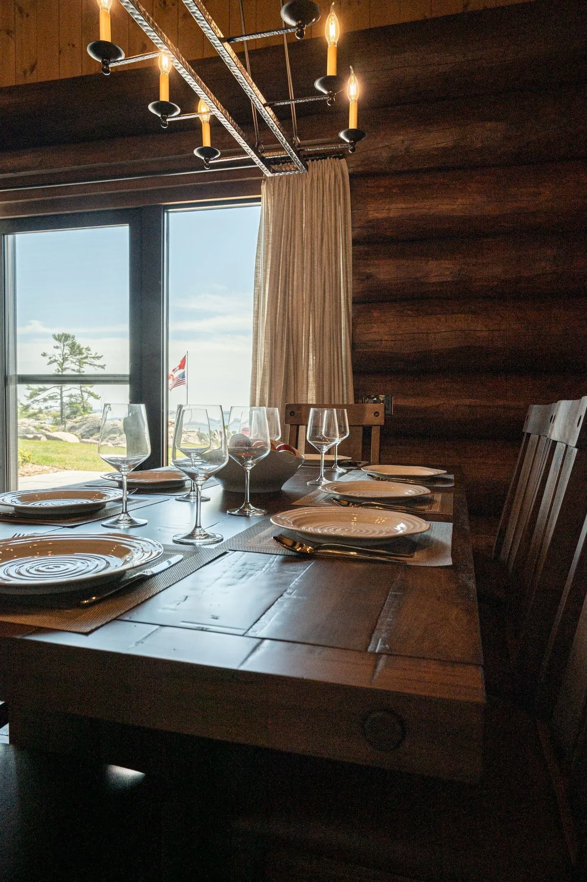 Cabin dining table beside windows looking toward the water at Killarney Mountain Lodge