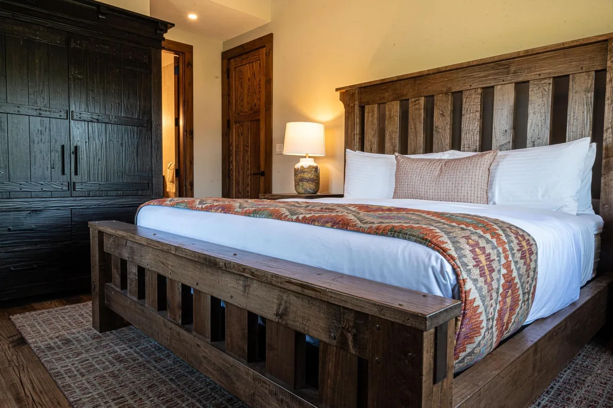 Cabin bedroom with a wood bed frame and matching cabinet at Killarney Mountain Lodge