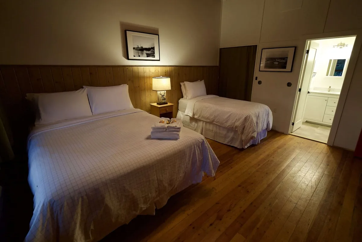 Pine Lodge room with two beds and a private bathroom doorway at Killarney Mountain Lodge