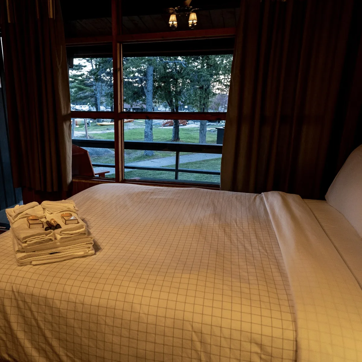 Porch Suite bed beside a channel-facing window at Killarney Mountain Lodge