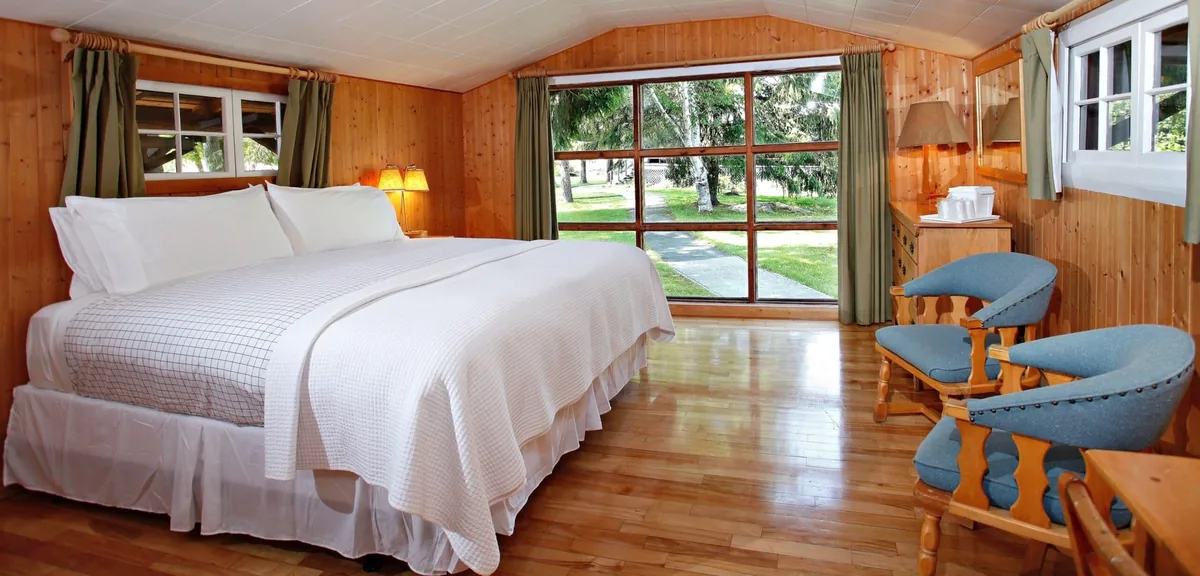 Killarney Cabin bed beside large windows at Killarney Mountain Lodge