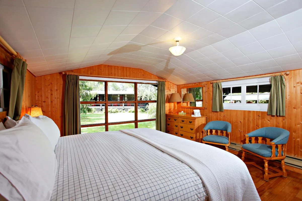 Killarney Cabin bedroom and sitting area with large windows at Killarney Mountain Lodge