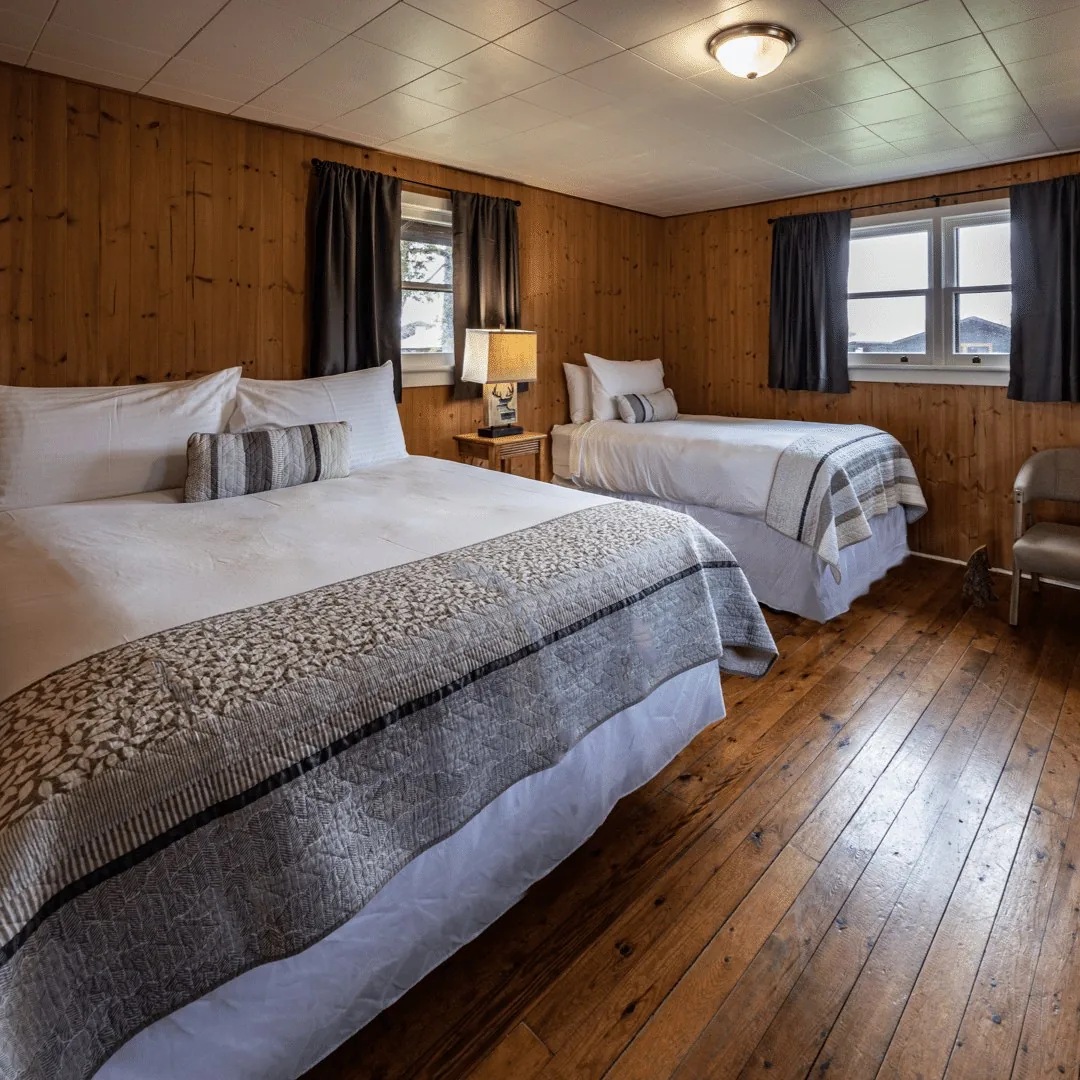 Georgian Bay Cabin bedroom with two beds and wood-paneled walls at Killarney Mountain Lodge