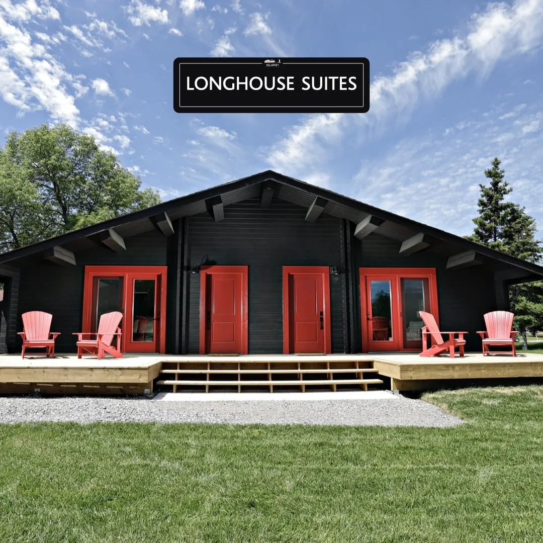 Long House Suites exterior with a lawn and red chairs at Killarney Mountain Lodge